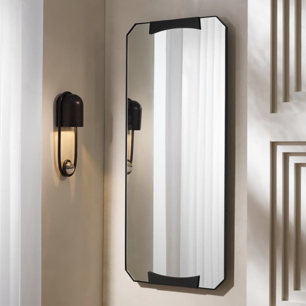 Wall-mounted mirror with black frame on a neutral wall