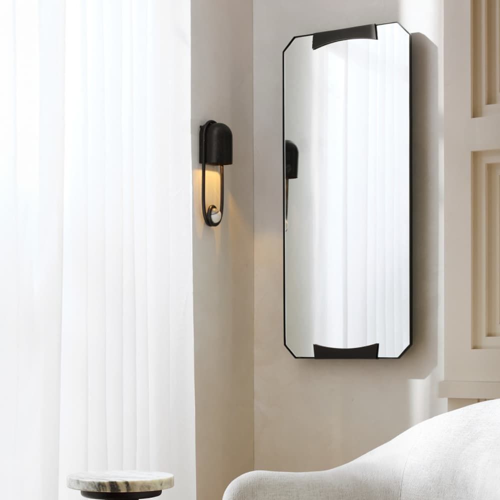 Modern wall-mounted mirror with black frame in a room setting