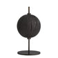Black spherical object on a stand against a white background