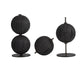 Set of black spherical decorative objects on stands against a white background