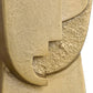 Close-up of a textured beige stone sculpture with a unique design.