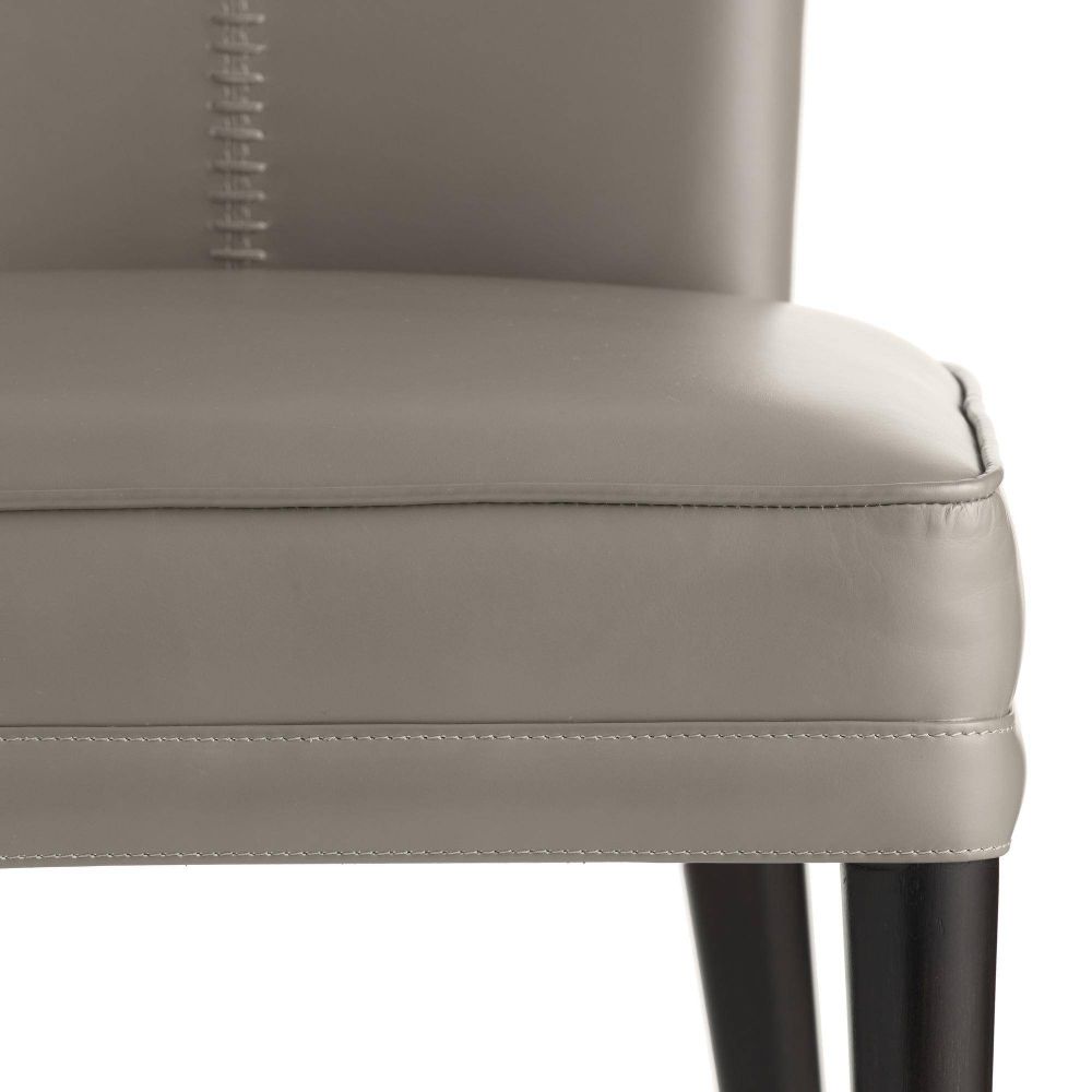 Close-up of a gray upholstered chair with stitching detail on a white background