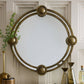 Decorative round mirror with gold frame on a wall