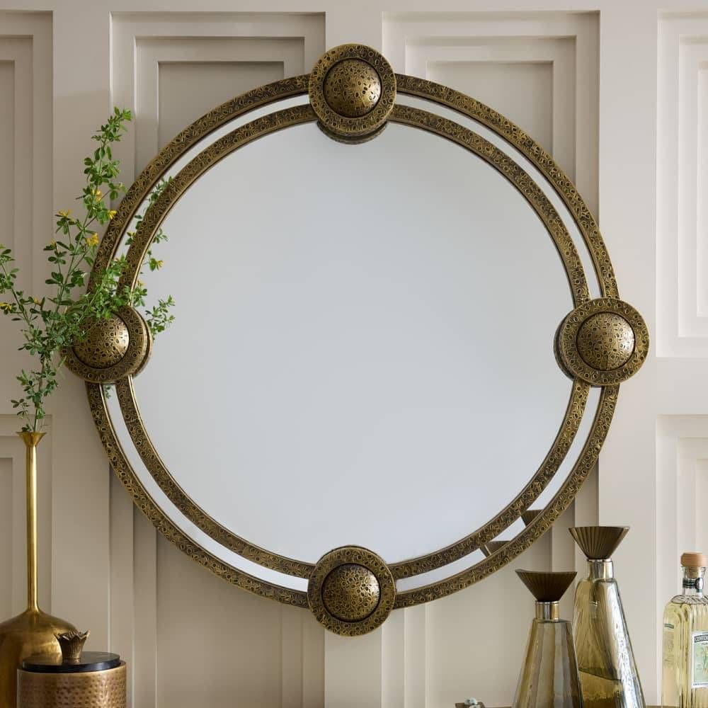 Decorative round mirror with gold frame on a wall