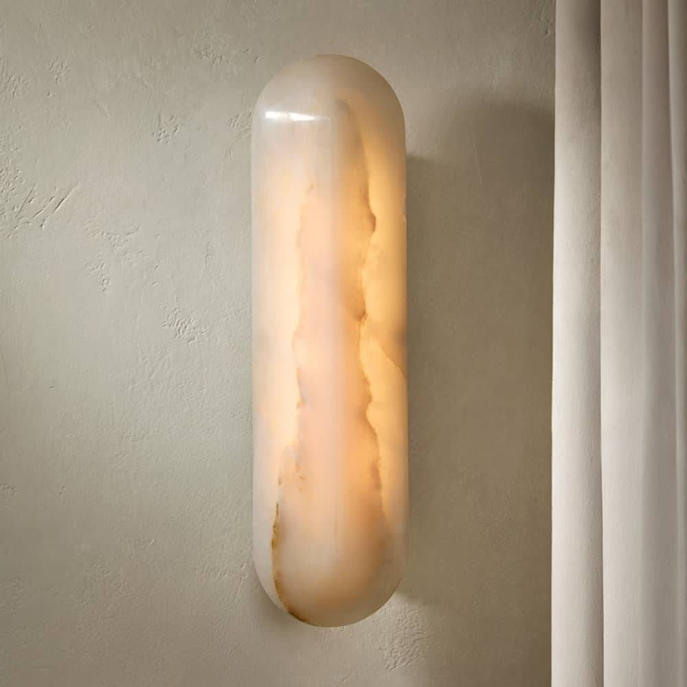 Wall-mounted cylindrical light fixture on a neutral wall.