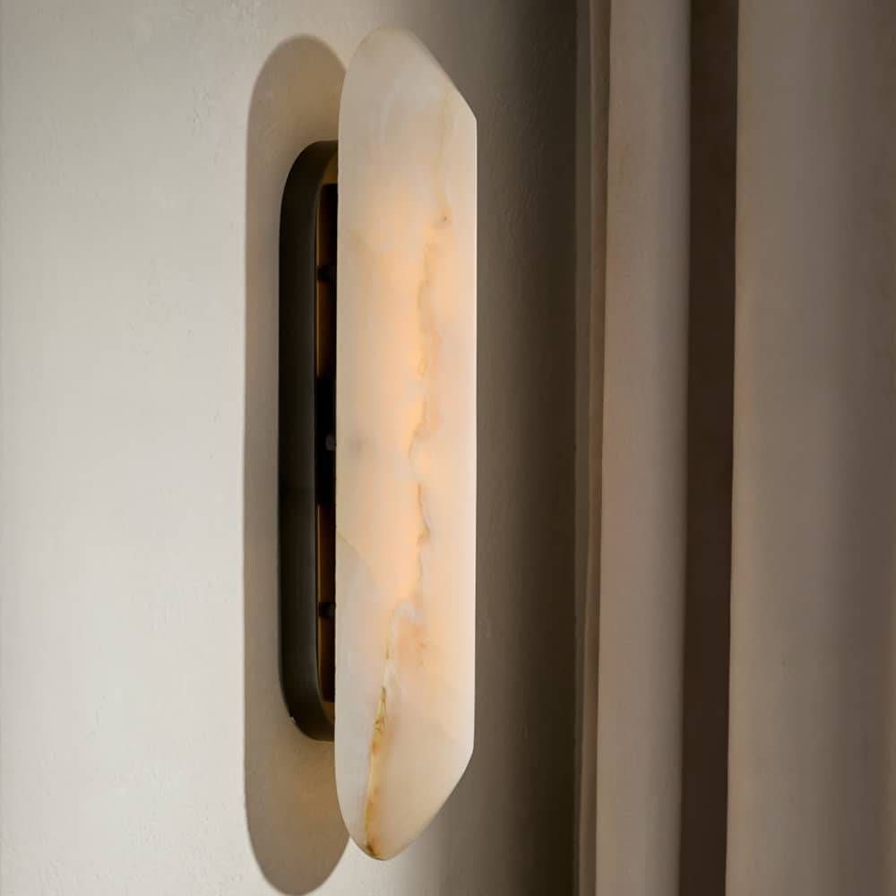 Wall-mounted light fixture with a warm glow on a neutral wall.