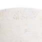 Close-up of a textured white surface with small black specks