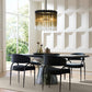 Modern dining room with black chairs and a stylish chandelier.