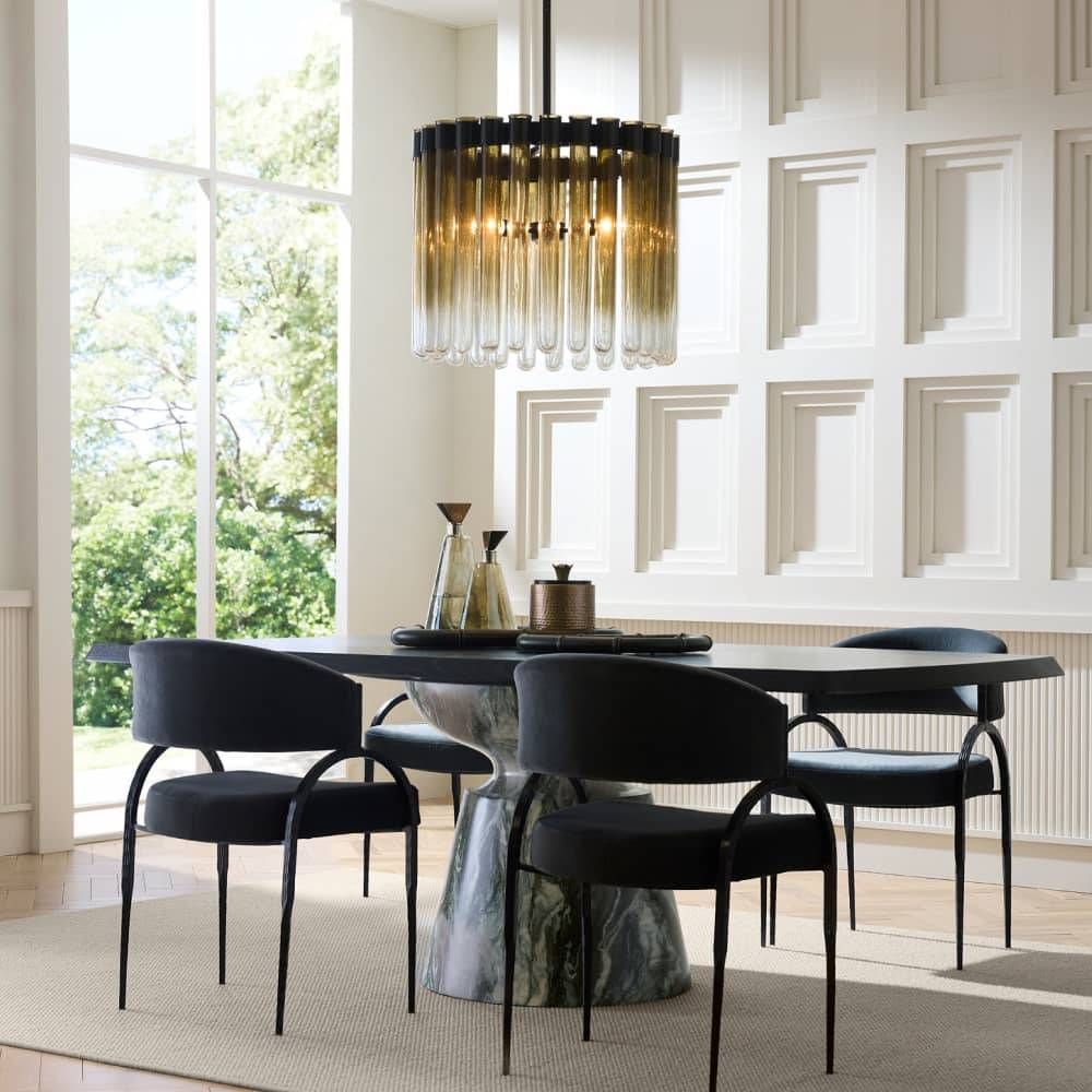 Modern dining room with black chairs and a stylish chandelier.