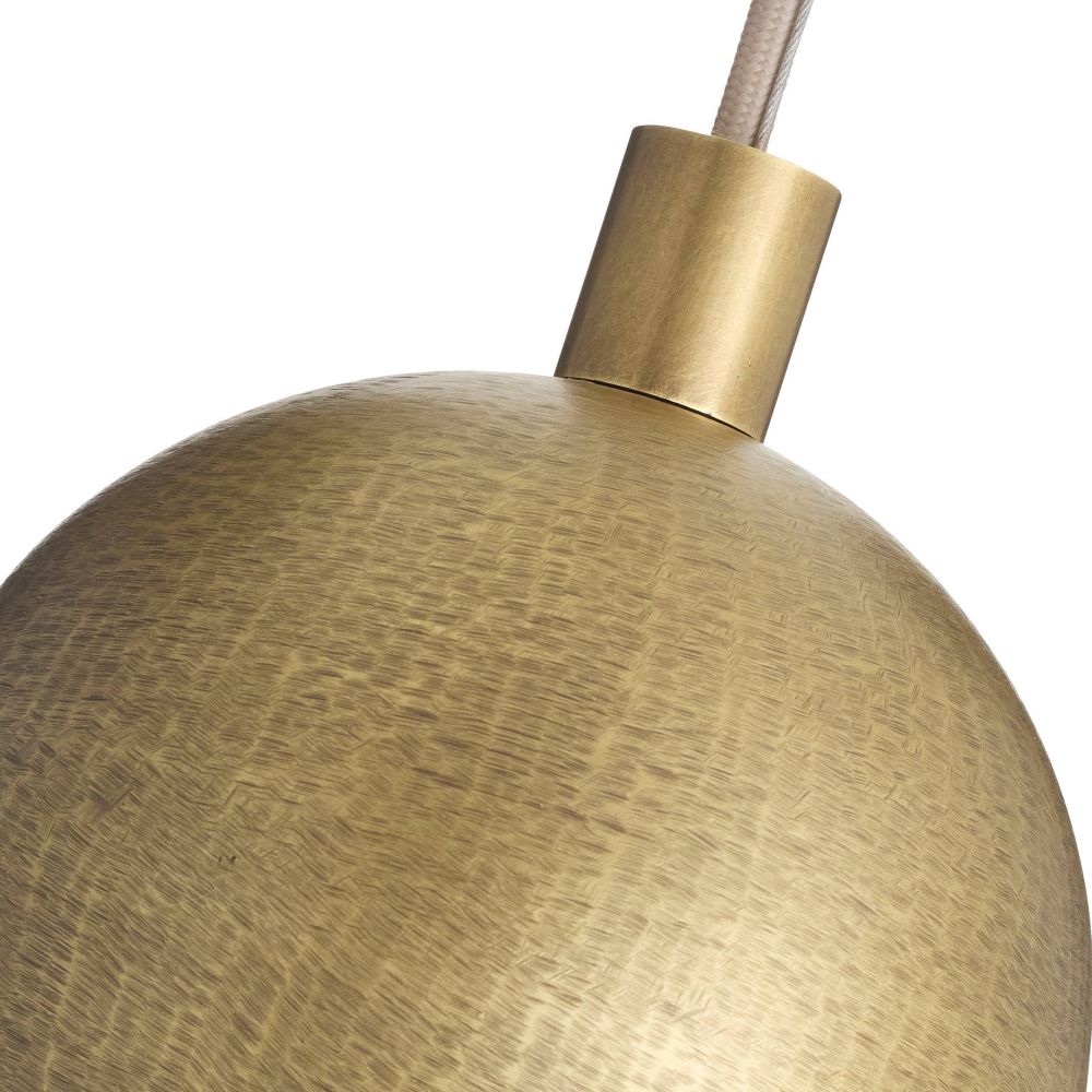Close-up of a gold pendant light with a textured finish on a white background