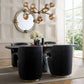 Dining room with a round table and black chairs, featuring a chandelier and decorative elements.