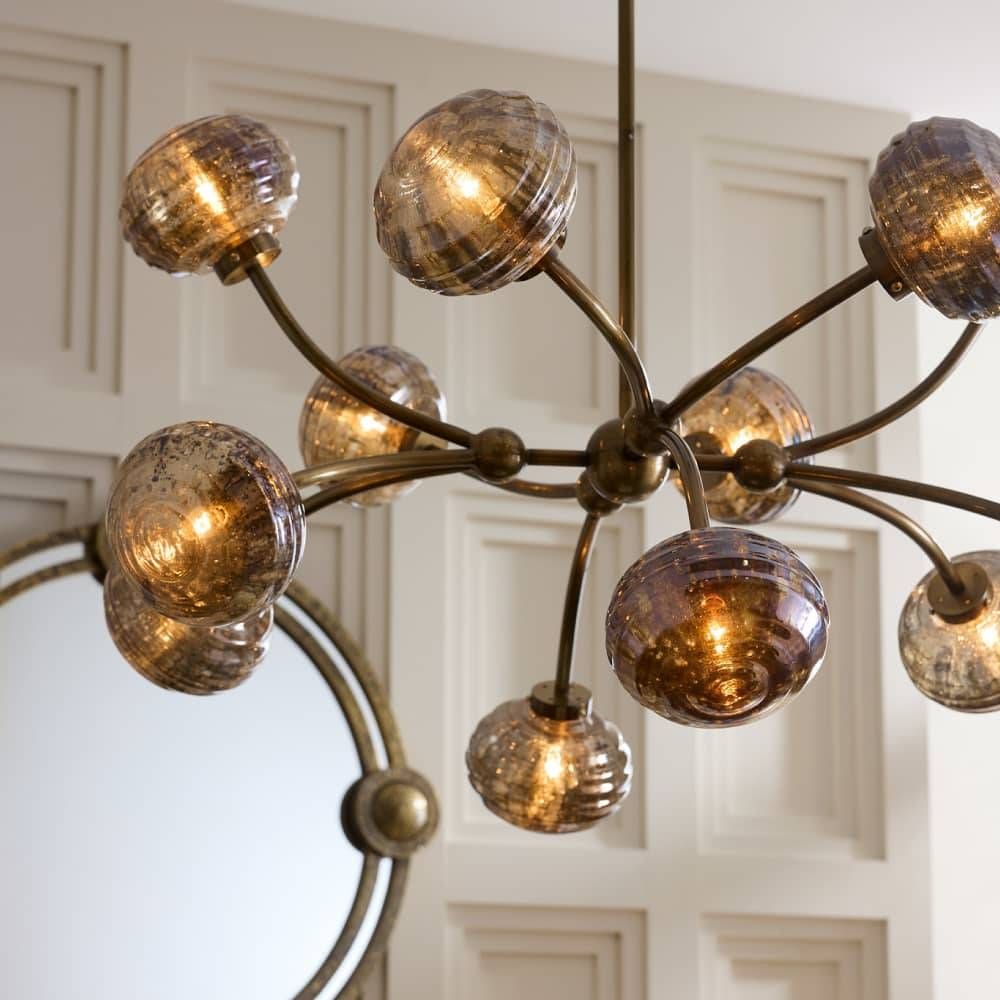 Chandelier with glass globe lights in a room with white paneled walls.