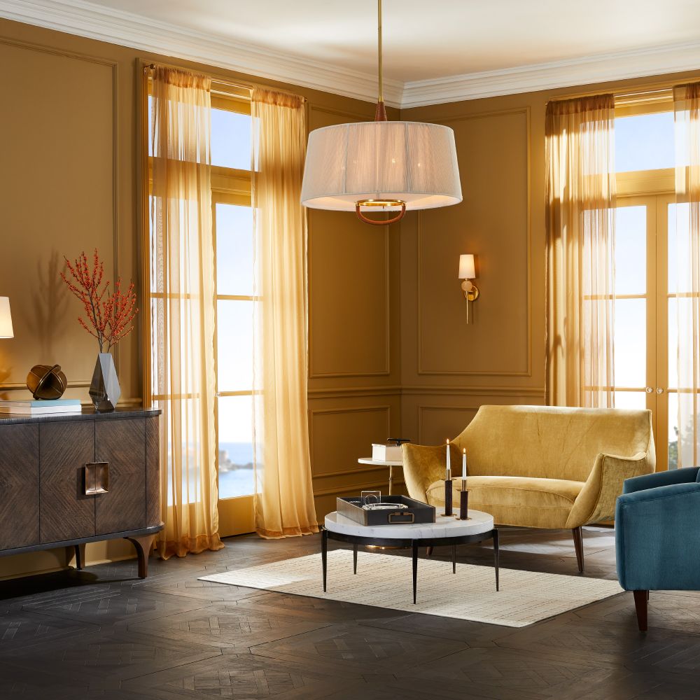 Luxurious living room with yellow armchair, blue sofa, and large windows.