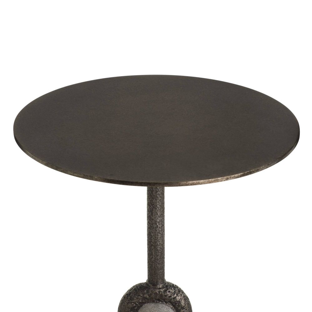 Round metal table with a textured base on a white background