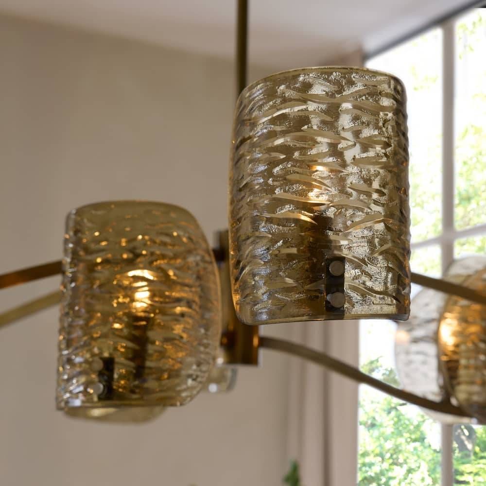Chandelier with textured glass shades in a room with a window