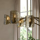 Chandelier with textured glass shades in a room with a window and plants.