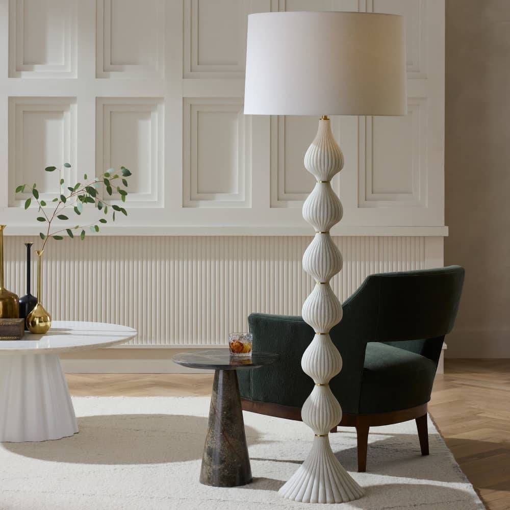 Decorative floor lamp in a living room setting with a chair and tables.
