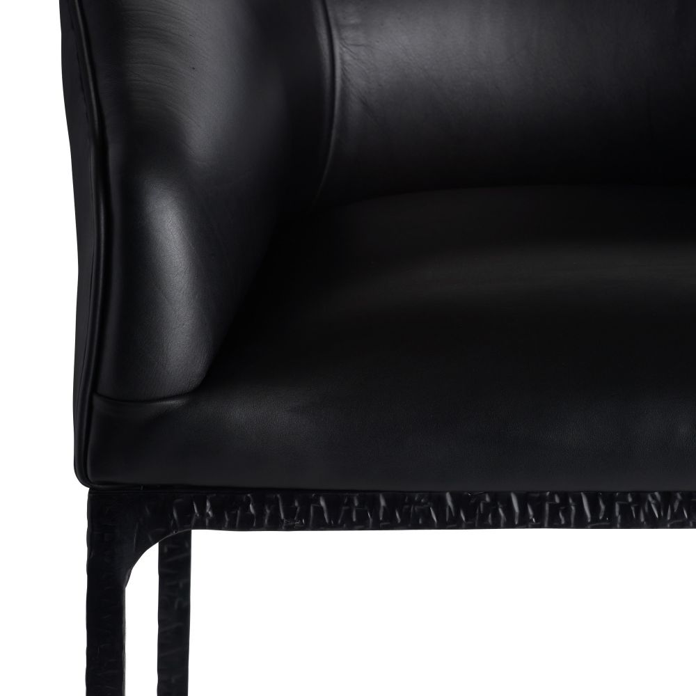 Close-up of a black leather chair corner on a white background