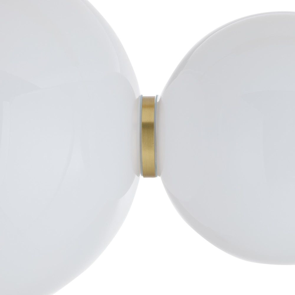 Close-up of a lamp with two white spherical shades and a gold accent on a light gray background
