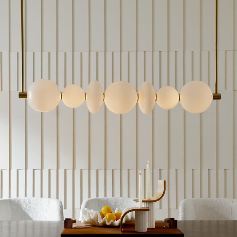 Modern pendant light fixture with round glass shades in a room setting.