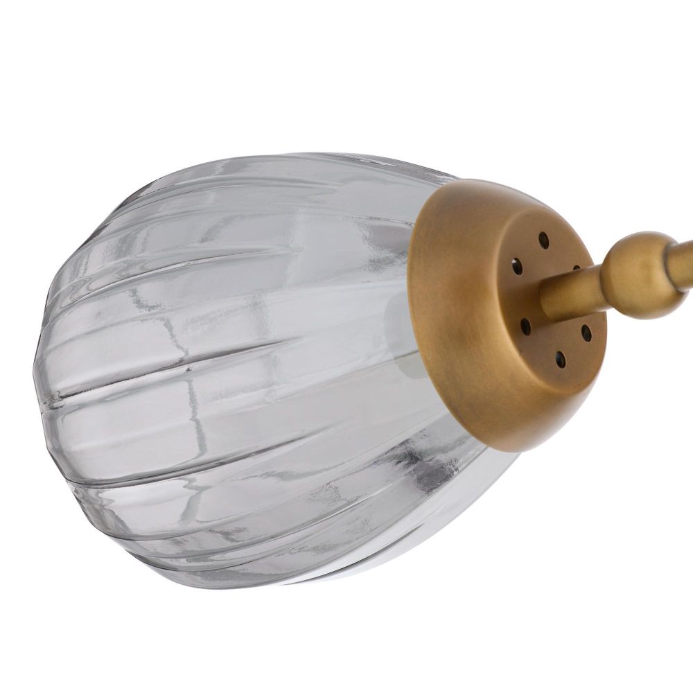 Clear glass light fixture with gold metal arm on a white background