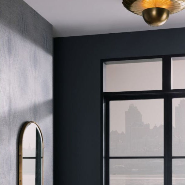 Modern interior with a round mirror on a textured wall and a glass door.