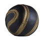 Black and gold spherical object with decorative patterns on a white background