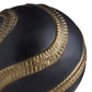 Close-up of a black and gold shoe with textured design on a white background