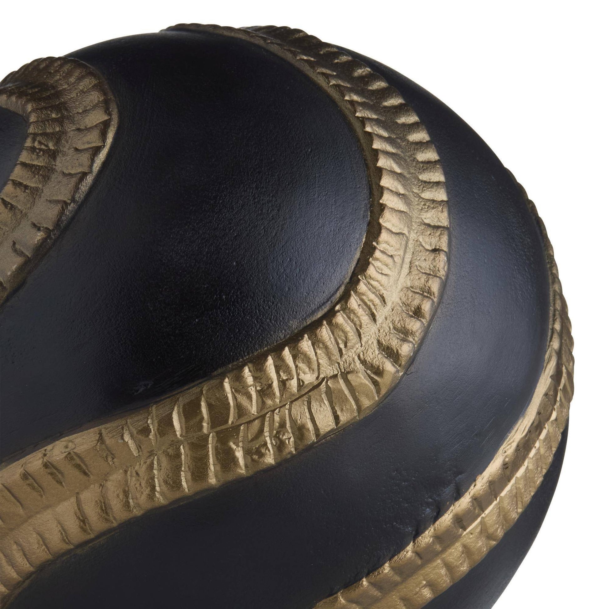 Close-up of a black and gold shoe with textured design on a white background