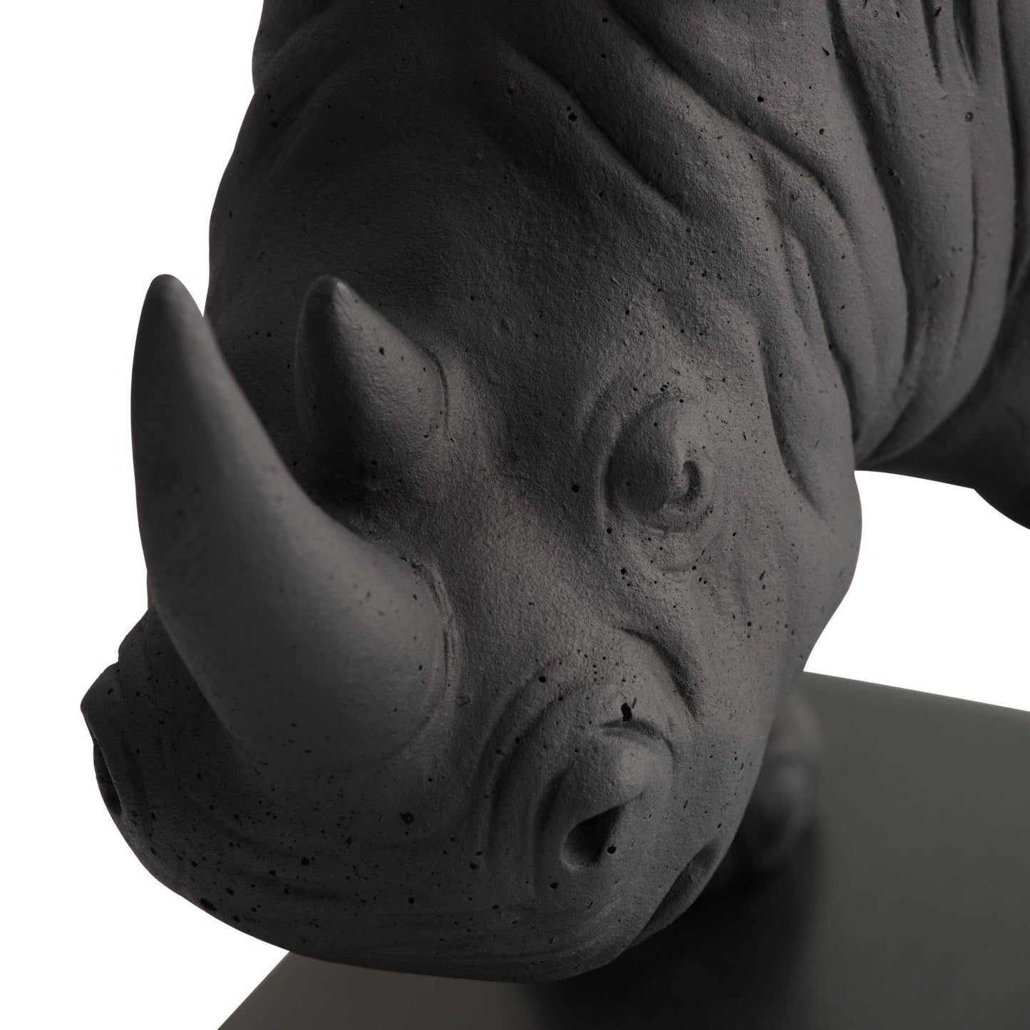 Close-up of a black rhinoceros head sculpture on a white background