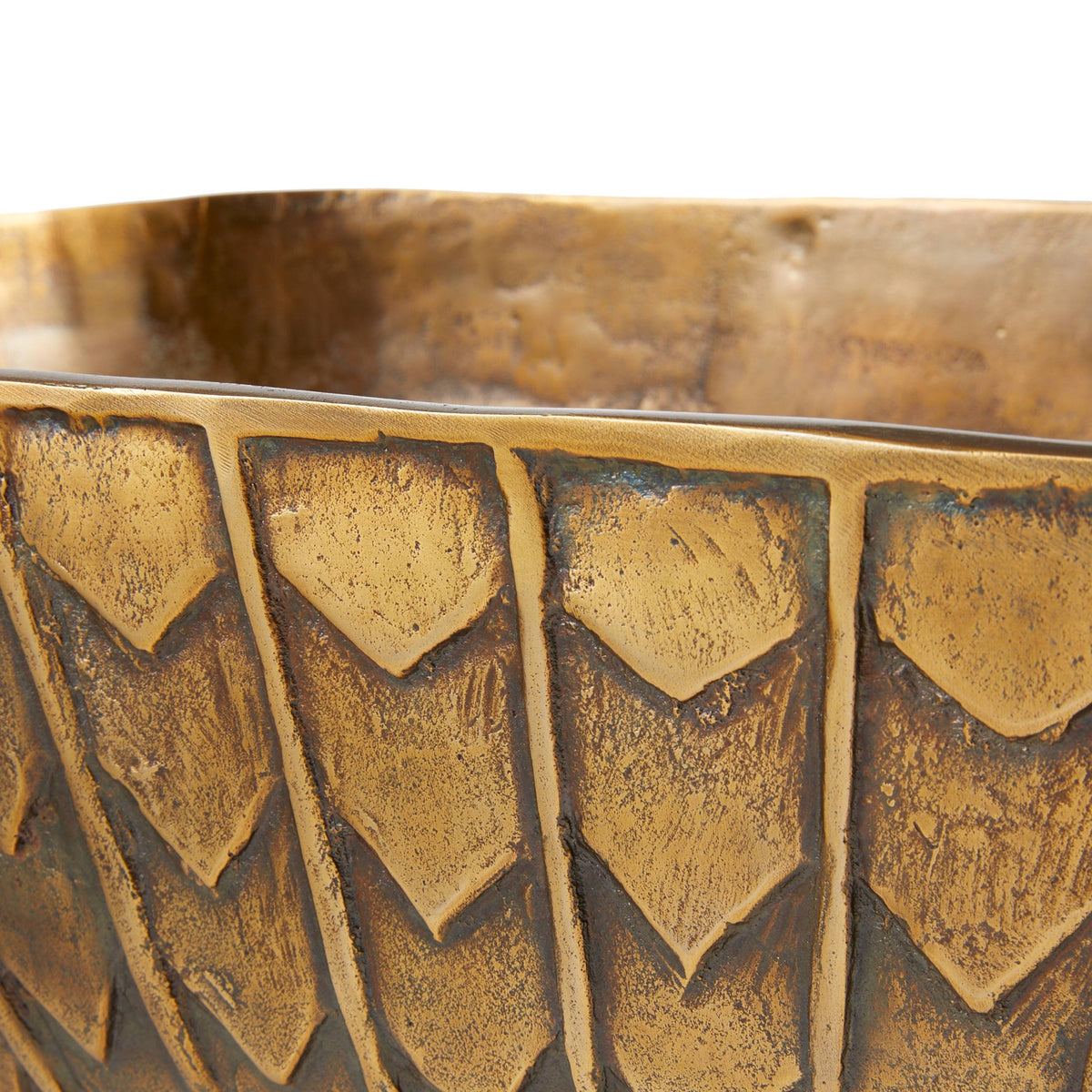 Close-up of a textured gold bowl with geometric patterns on a white background