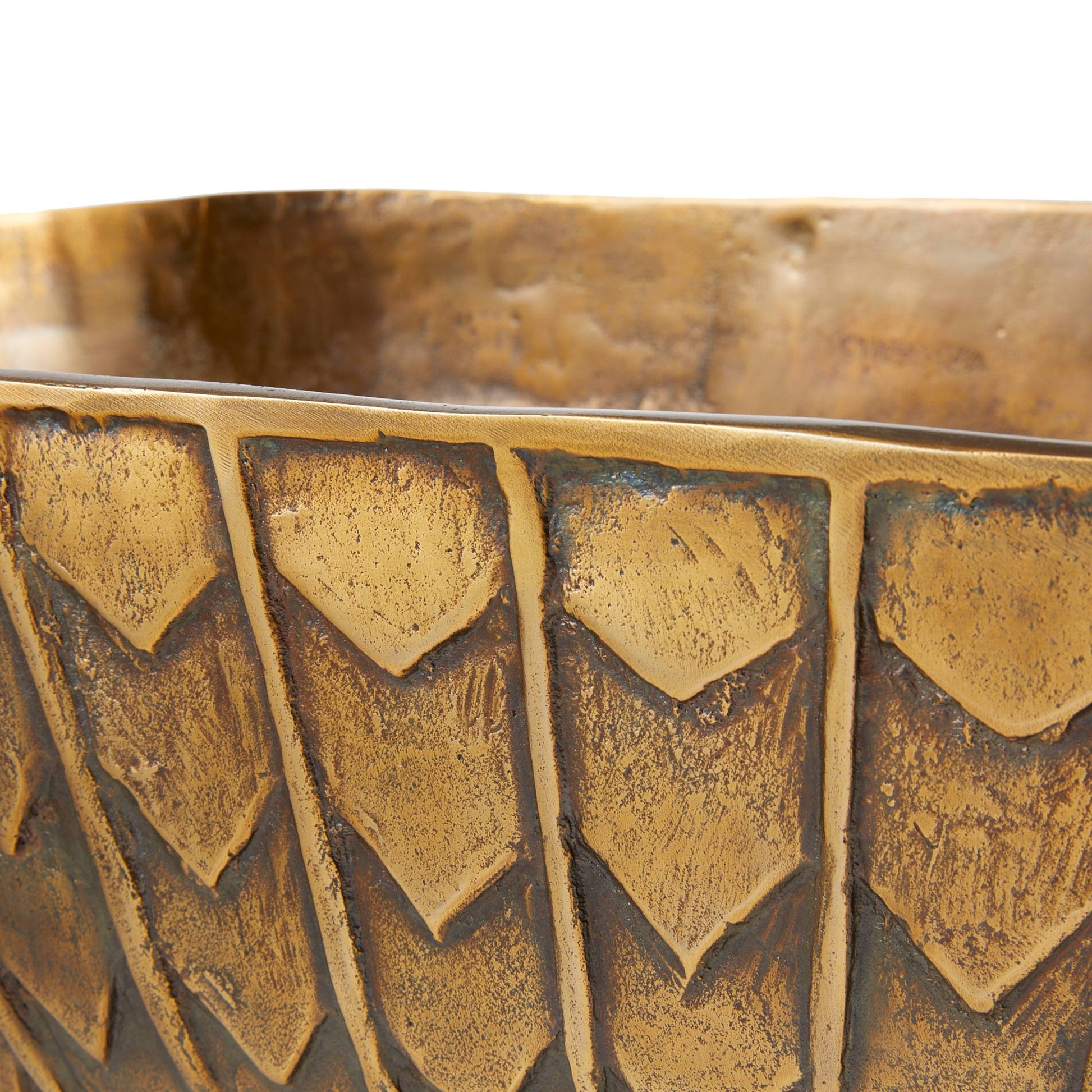 Close-up of a textured gold bowl with geometric patterns on a white background