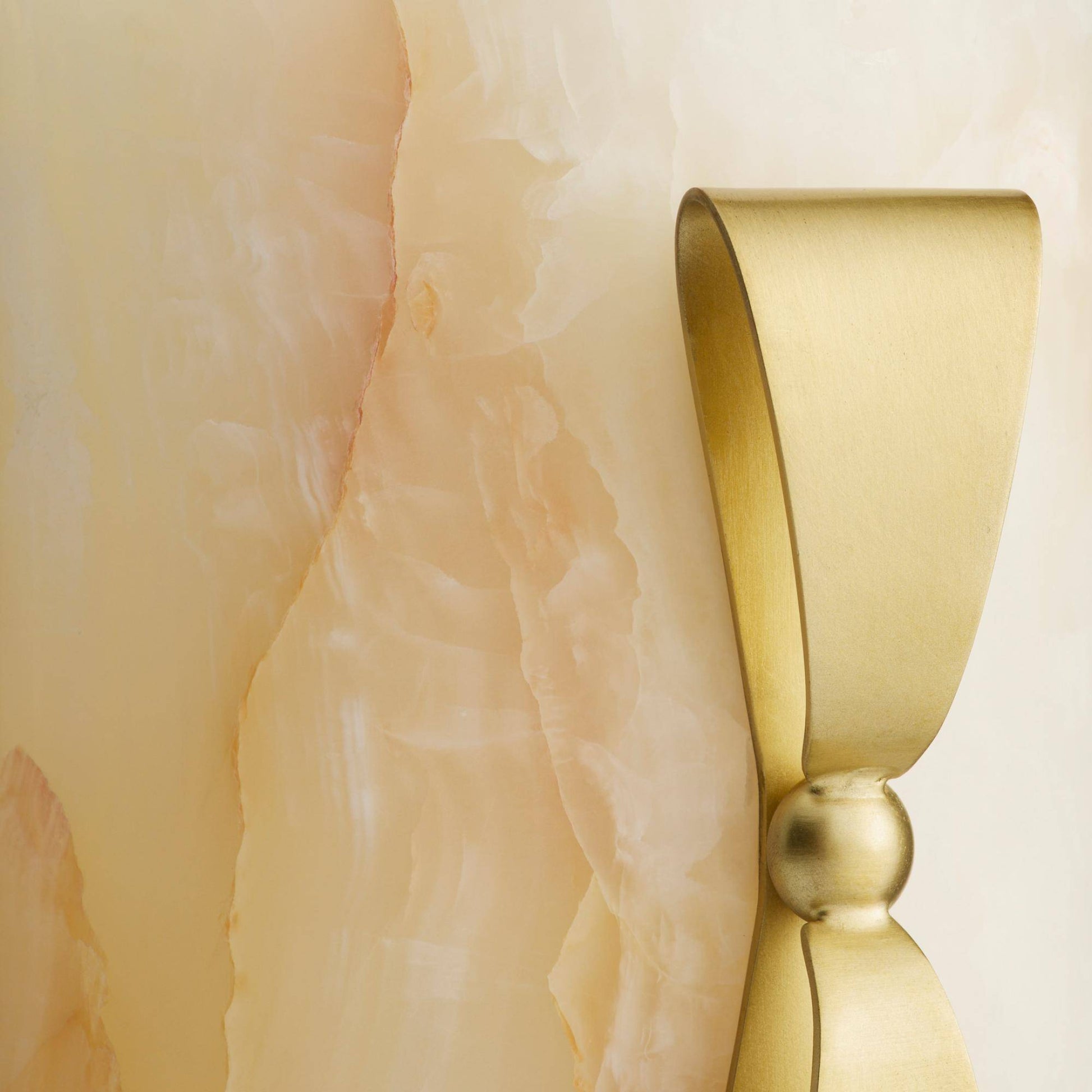 Gold bow tie on a textured beige background