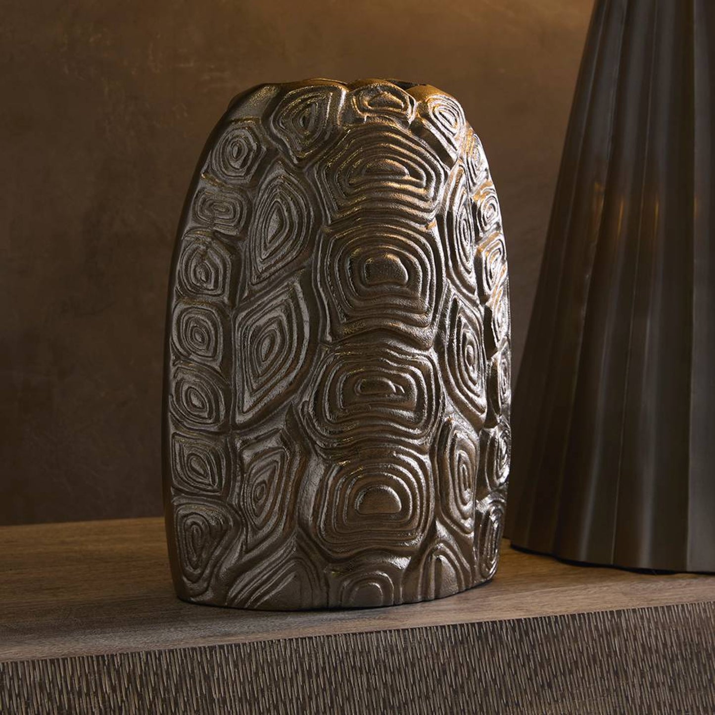 Decorative aluminum piece with textured surface on a wooden surface