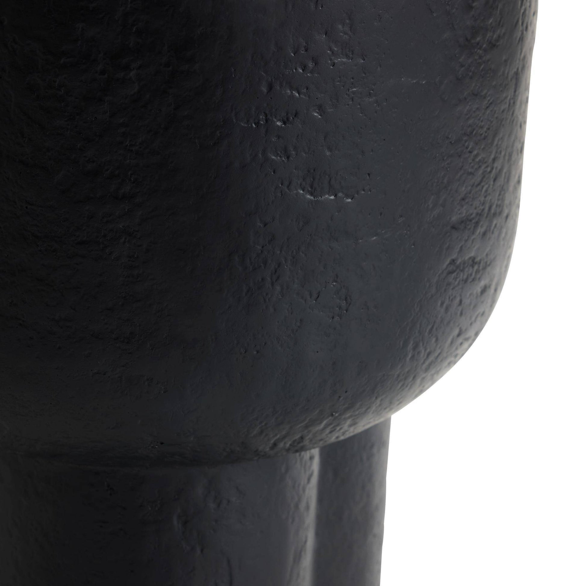 Close-up of a textured black vase on a white background
