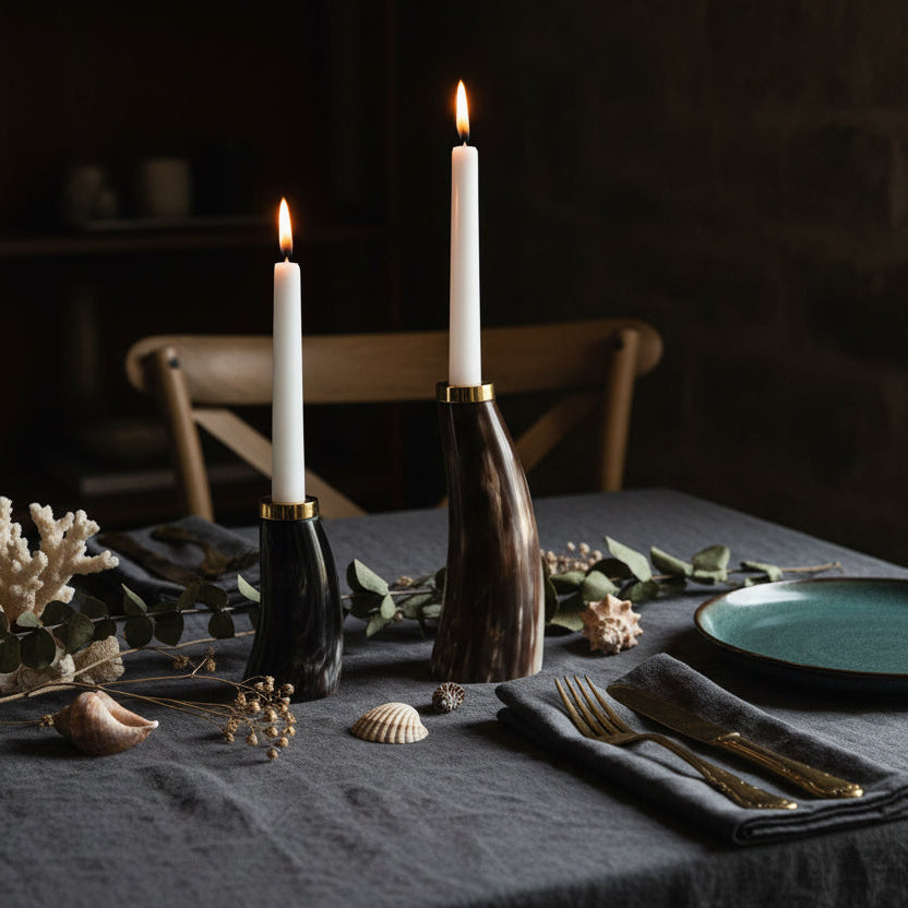 Two candle holders made from dark wood with gold bases on a white background