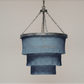Chandelier with blue fabric shades hanging against a plain wall