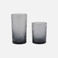 Two gray textured glass tumblers on a white background