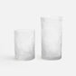 Two textured glass tumblers on a white background