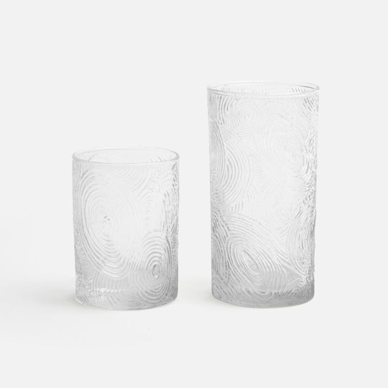 Two textured glass tumblers on a white background