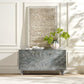 Decorative cabinet with a textured wall and plant in the background