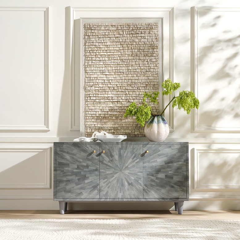 Decorative cabinet with a textured wall and plant in the background