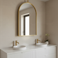 Bathroom vanity with gold-framed mirror and white sinks.