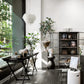 Modern interior with a bookshelf, plants, and decorative items.