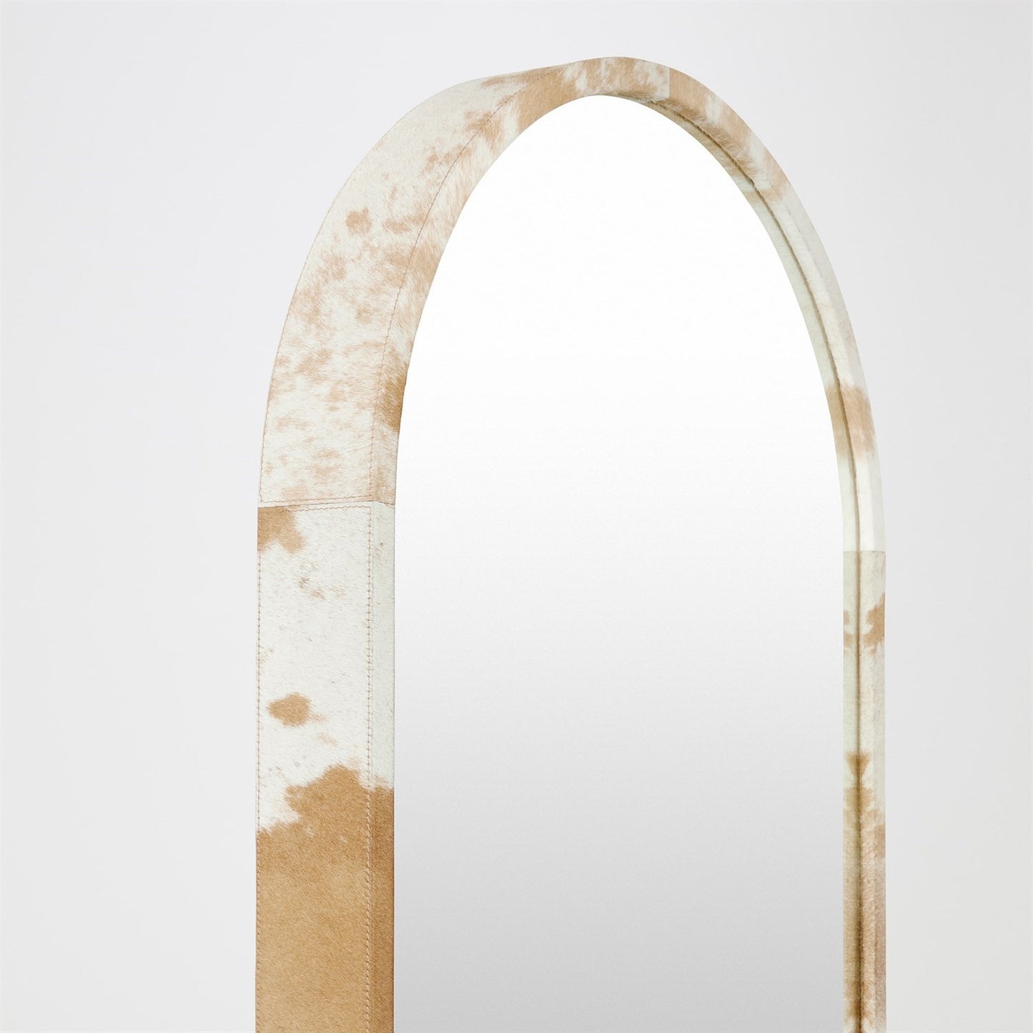 Long, narrow mirror with a brown and white patterned frame on a light gray background