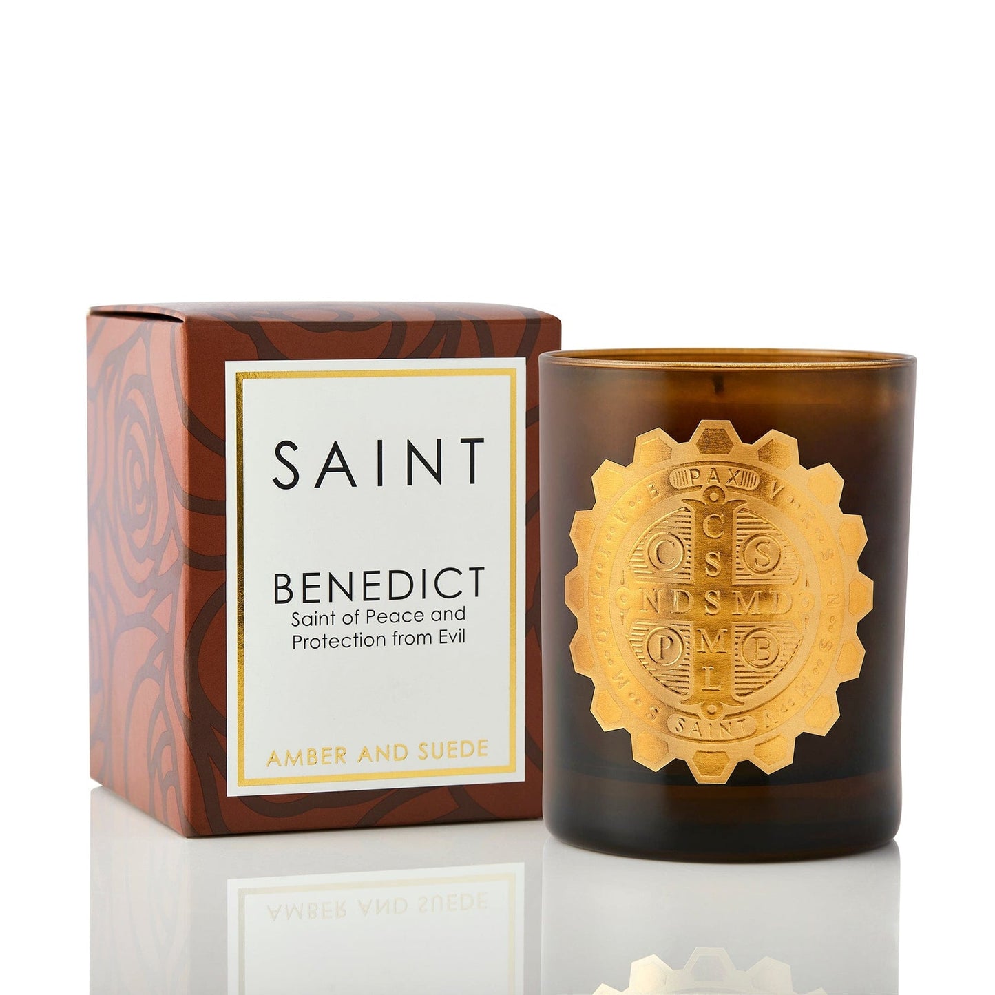 Candle with decorative emblem and packaging labeled 'Saint Benedict' on a white background