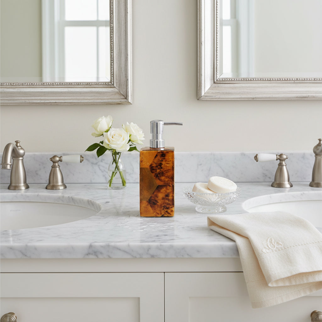 A rectangular resin soap dispenser with a polished silver pump, featuring a marbled amber and brown pattern on a light gray background.