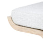 White textured bath mat on a wooden stand with a white background