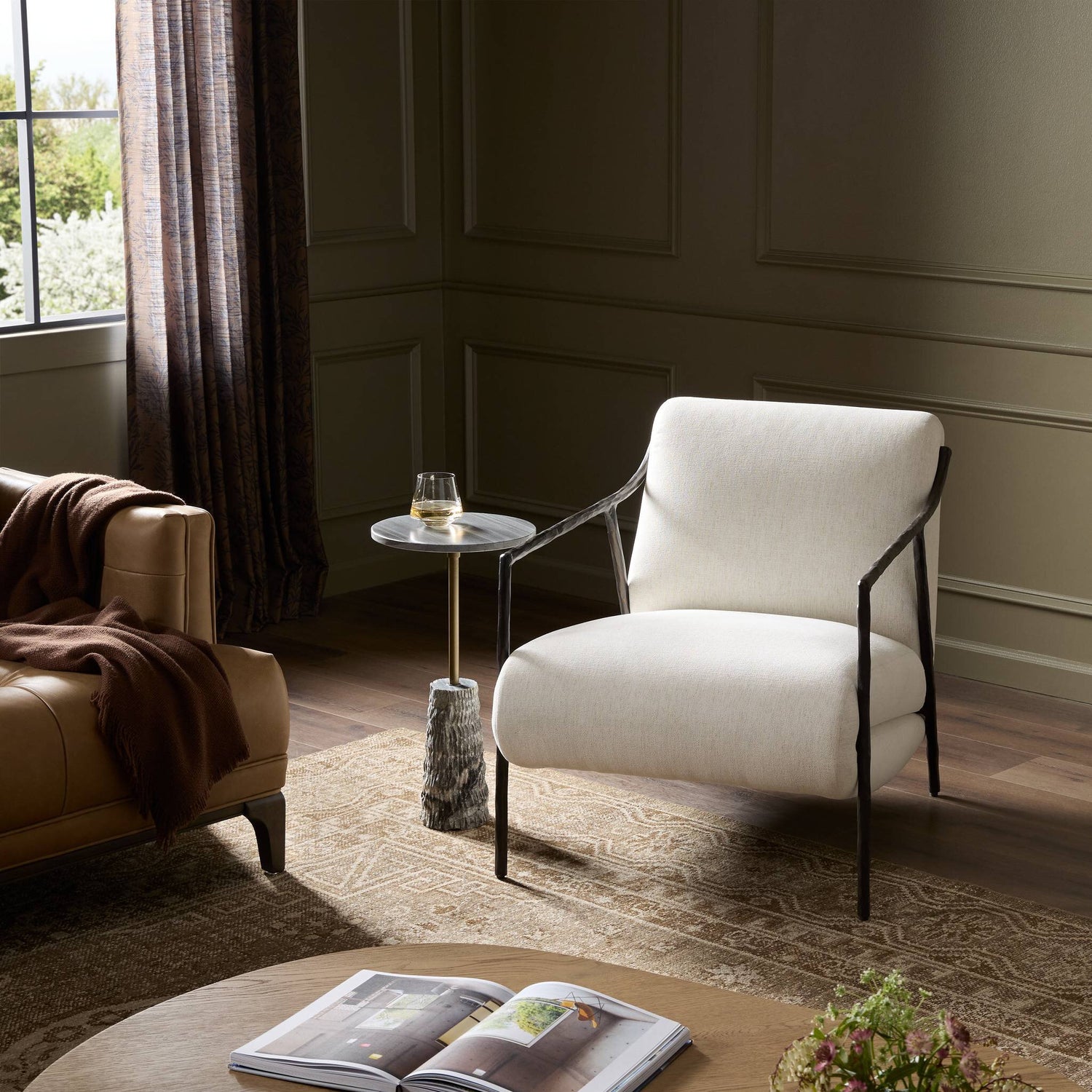 Modern living room with a white armchair, brown sofa, and small table.