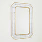 Decorative mirror with a gold and white frame on a light gray background